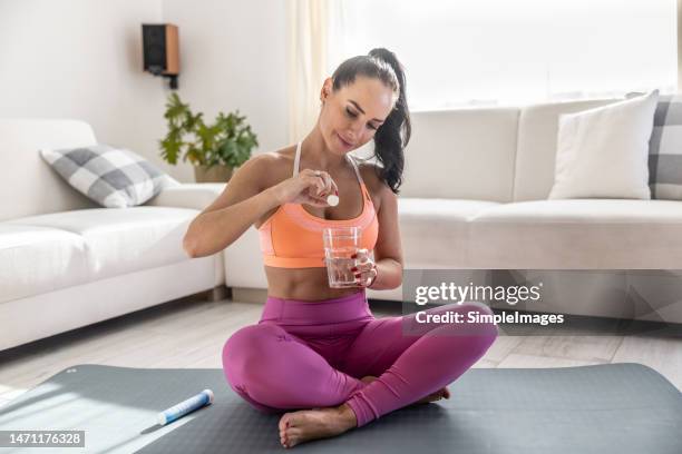 young woman i sportswear with magnesia effervescent tablet and glass of pure or mineral water. - sport tablet stockfoto's en -beelden