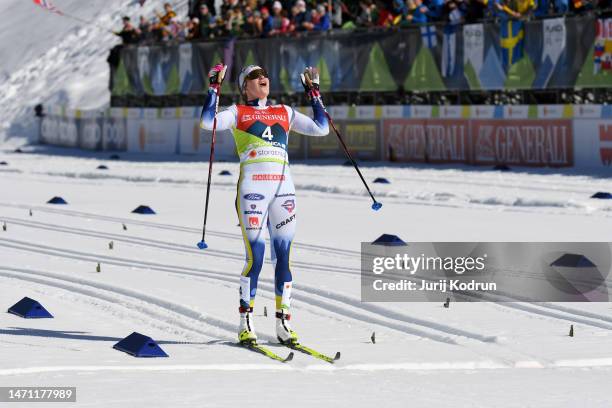 Gold medalist Ebba Andersson of Sweden celebrates victory as she crosses the finish line to win the Cross-Country Women's 30km Mass Start Classic at...