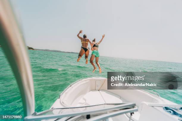 jumping off from a speedboat - spring break stock pictures, royalty-free photos & images
