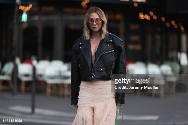 Karin Teigl seen wearing Gucci sunglasses, The Frankie Shop black leather biker jacket, H&M Studio black cropped top, H&M Studio light apricot /...
