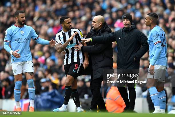 Pep Guardiola, Manager of Manchester City, attempts to break up a clash between Callum Wilson of Newcastle United and Manuel Akanji of Manchester...