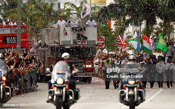 Fans cheer as the buses pass during a celebration parade for the 2012 NBA Champion Miami Heat on June 25, 2012 in Miami, Florida.