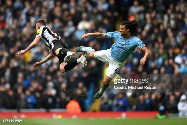 Sean Longstaff of Newcastle United and Nathan Ake of Manchester City clash during the Premier League match between Manchester City and Newcastle...