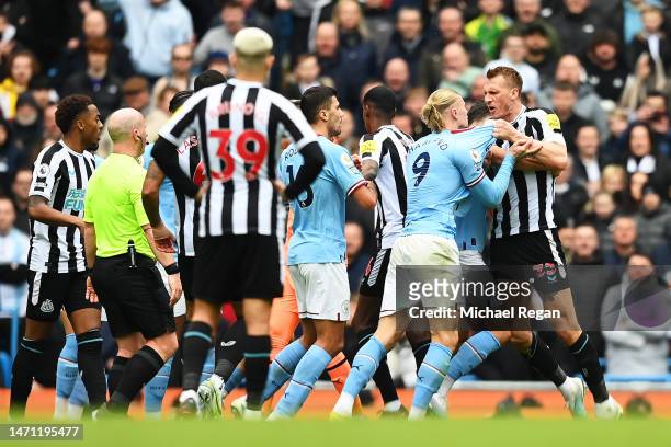 Erling Haaland of Manchester City and Dan Burn of Newcastle United clash during the Premier League match between Manchester City and Newcastle United...