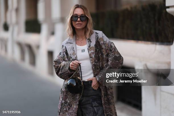Karin Teigl seen wearing Andy Wolf brown sunglasses with blue lenses, Munthe khaki green / brown flower pattern long coat, The Attico grey oversized...