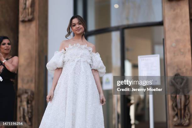 Maddie Baby seen wearing a white shoulder free tulle dress with puff sleeves before the Giambattista Valli show on March 03, 2023 in Paris, France.