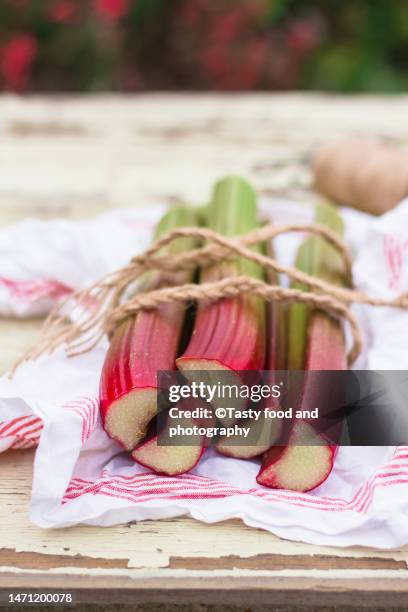 rhubarbs on the table outdoors - rabarber stockfoto's en -beelden