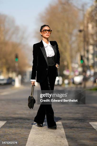 Heart Evangelista wears brown sunglasses, diamonds earrings, a white ruffled neck shirt, a black velvet blazer jacket, a matching black velvet with a...