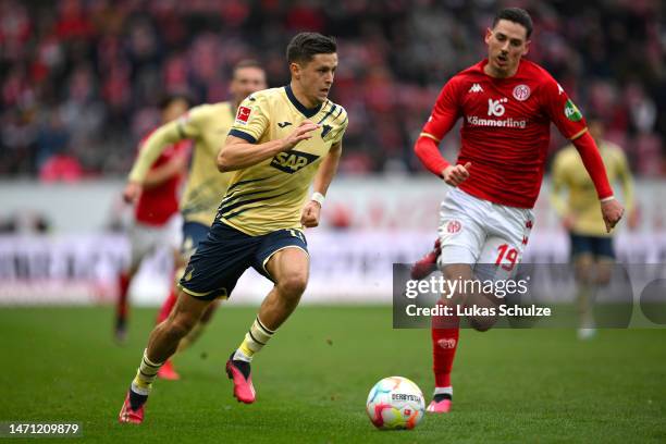 Christoph Baumgartner of TSG Hoffenheim runs with the ball whilst under pressure from Anthony Caci of 1.FSV Mainz 05 during the Bundesliga match...