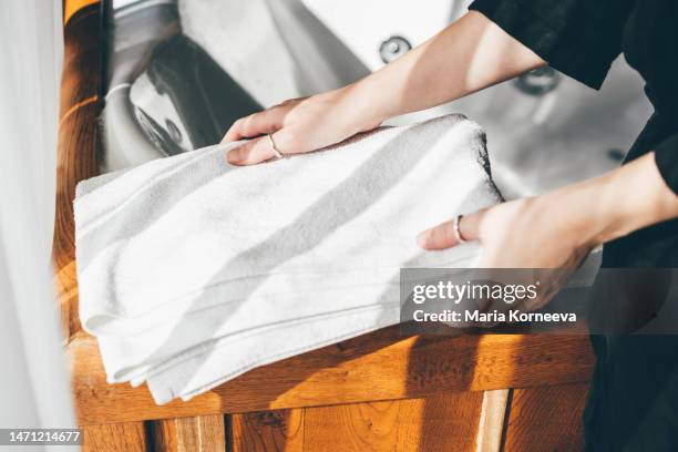 woman puts white bath towels in the bathroom. - bath towels stock-fotos und bilder