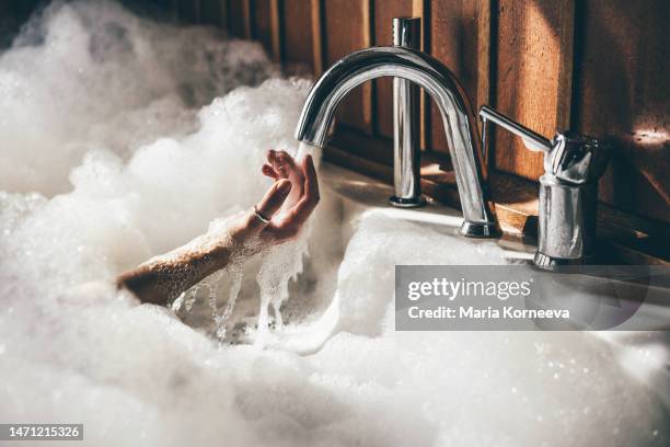 woman holds her hands underwater in a bath. - woman shower bath stock-fotos und bilder