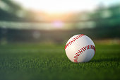 Baseball ball in a grass of baseball arena stadium.