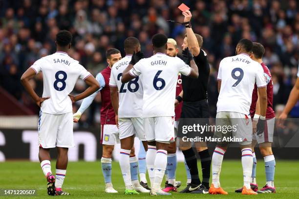 Referee Craig Pawson shows a red card to Cheick Doucoure of Crystal Palace during the Premier League match between Aston Villa and Crystal Palace at...
