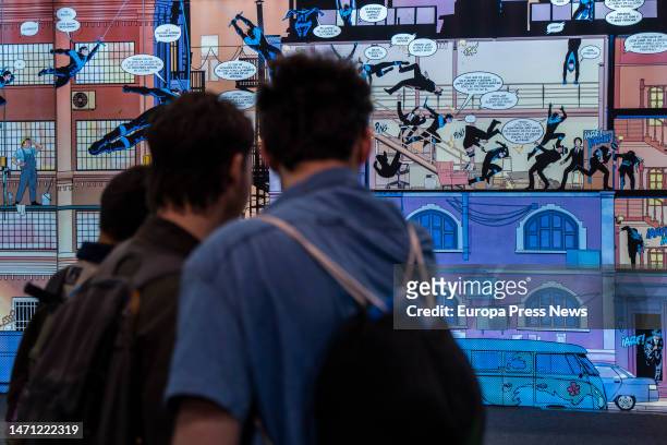 Several people look at a comic on display at the third edition of the Salon del Comic de Valencia, on March 4 in Valencia, Valencian Community,...