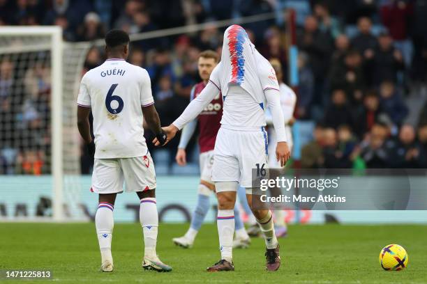 Joachim Andersen of Crystal Palace hides his face with his shirt as he interacts with teammate Marc Guehi following the Premier League match between...