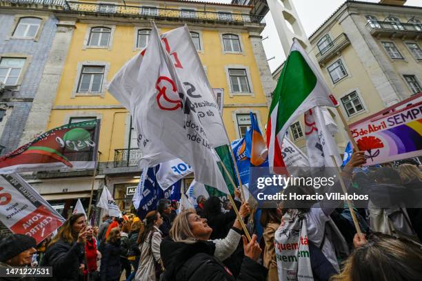 Teachers wave flags while marching from Rossio Square for better working conditions to the Portuguese Parliament during a strike called by the unions...