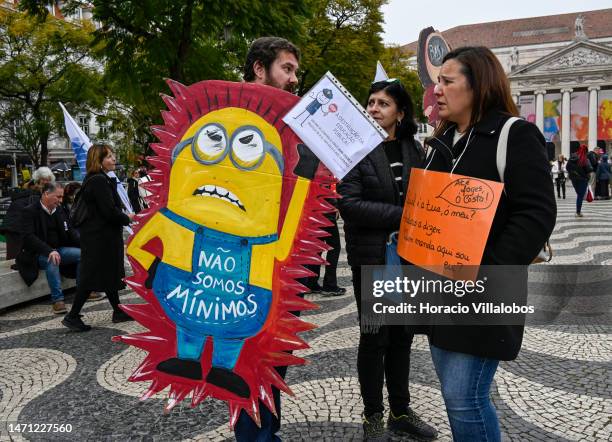 Teachers hold signs in Rossio Square fbefore marching or better working conditions to the Portuguese Parliament during a strike called by the unions...