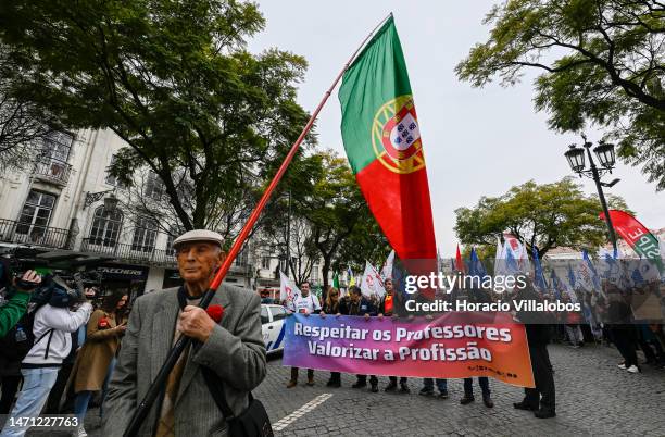 Year-old pensioner holding a Portuguese flag opens the rally as teachers protest from Rossio Square for better working conditions to the Portuguese...