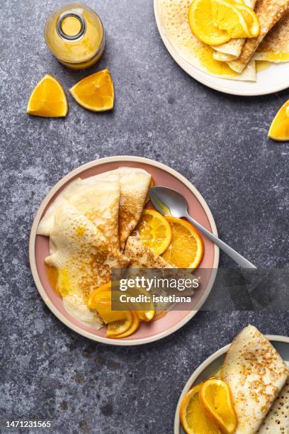 stack of fresh homemade crepes with orange slices and orange juice sauce on plate, crepes suzette - molho de sobremesa imagens e fotografias de stock