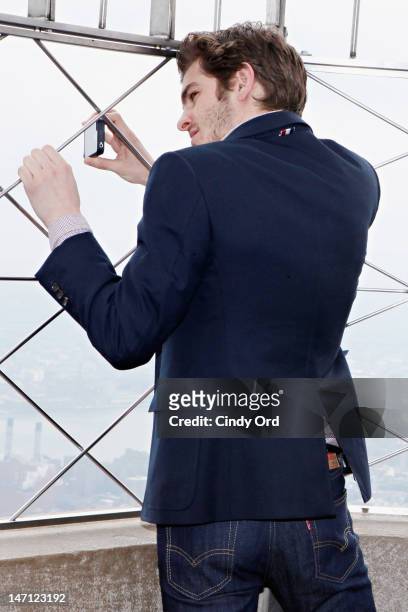 Actor Andrew Garfield takes pictures with his i-phone on the observatory deck of The Empire State Building on June 25, 2012 in New York City.