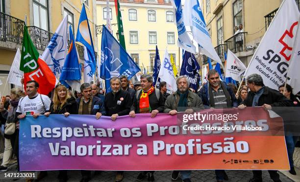 Leader Mario Nogueira walks in front row behind a banner as teachers protest for better working conditions from Rossio Square to the Portuguese...