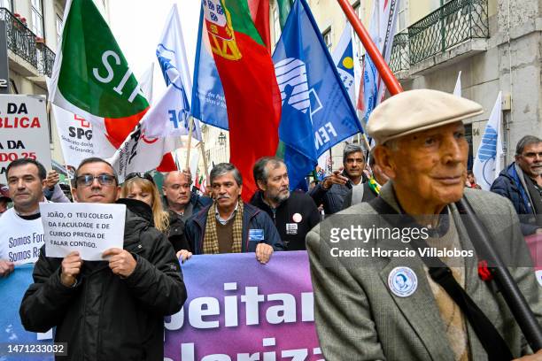 Leader Mario Nogueira walks in front row behind a banner as teachers protest for better working conditions from Rossio Square to the Portuguese...