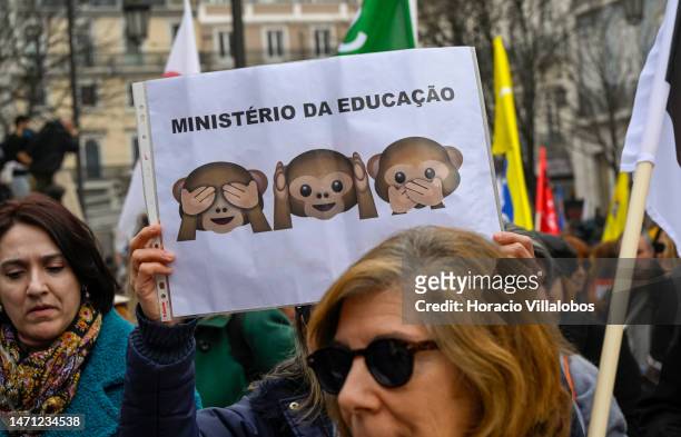 Teachers hold signs while marching in protest for better working conditions from Rossio Square to the Portuguese Parliament during a strike called by...