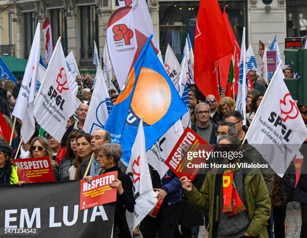 Teachers wave flags while marching in protest for better working conditions from Rossio Square to the Portuguese Parliament during a strike called by...