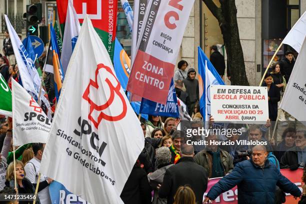 Teachers wave flags while marching in protest for better working conditions from Rossio Square to the Portuguese Parliament during a strike called by...
