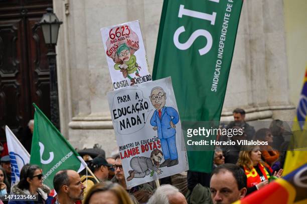 Teachers hold signs while marching in protest for better working conditions from Rossio Square to the Portuguese Parliament during a strike called by...