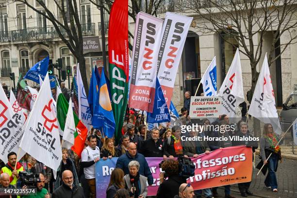 Teachers wave flags while marching in protest for better working conditions from Rossio Square to the Portuguese Parliament during a strike called by...