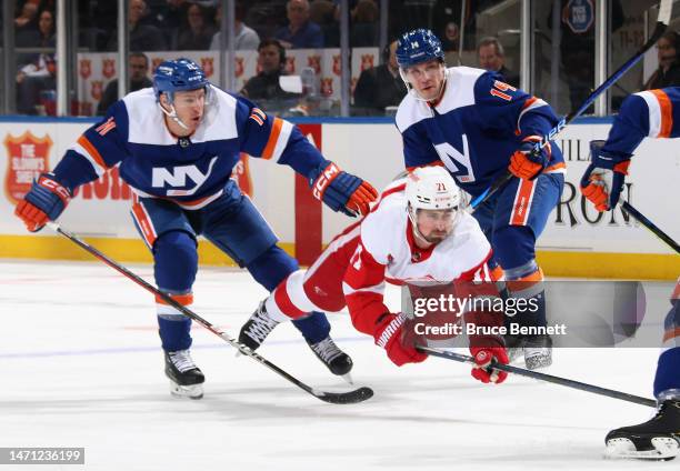 Dylan Larkin of the Detroit Red Wings is tripped up by Zach Parise of the New York Islanders during the first period at the UBS Arena on March 04,...