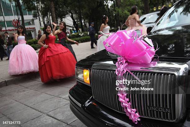 Fifteen-year-old girls return to their limousine after a photo shoot at Mexico's Angel of Independence monument on June 23, 2012 in Mexico City,...