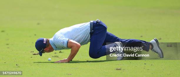 Justin Thomas of The United States examines the condition of his golf ball before he plays his second shot on the first hole during the second round...