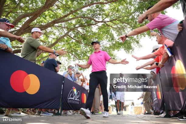 Jordan Spieth of the United States shakes hands with fans as he walks to the first tee during the third round of the Arnold Palmer Invitational...