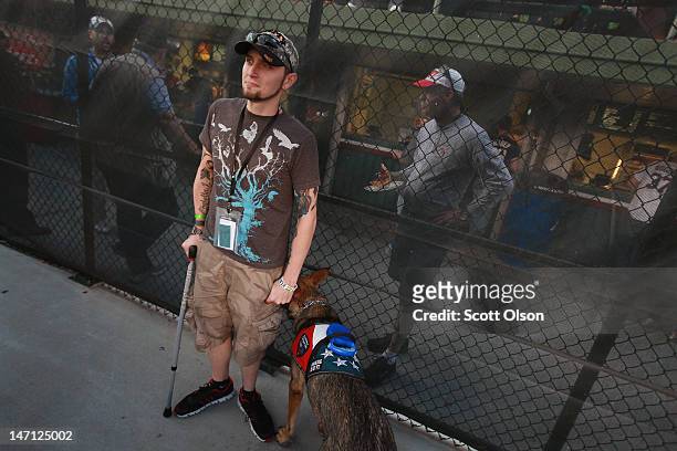 Brad Schwarz, with his service dog Panzer, attends a Chicago Cubs' game with a group of veterans from the Wounded Warrior Project at Wrigley Field on...