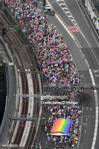 In this aerial view, the Progress Pride flag is carried over the Sydney Harbour Bridge as people take part in Pride March on March 05, 2023 in...