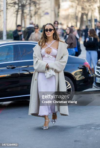 Tamara Kalinic wears pink cut out dress, coat, white bag, heels outside Giambattista Valli during the Paris Fashion Week - Womenswear Fall Winter...