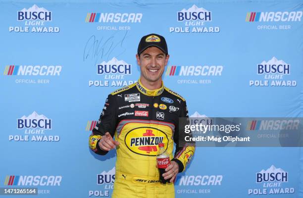 Joey Logano, driver of the Pennzoil Ford, poses for photos after winning the pole award during practice for the NASCAR Cup Series Pennzoil 400 at Las...