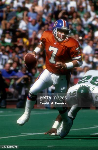 Quarterback John Elway of the Denver Broncos rolls out in the game between the Denver Broncos vs the Philadelphia Eagles at Veterans Stadium on...