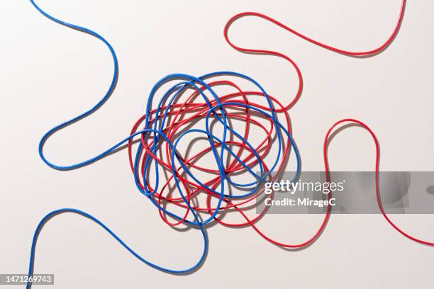 blue and red colored ropes tangled with each other - partisan politics fotografías e imágenes de stock