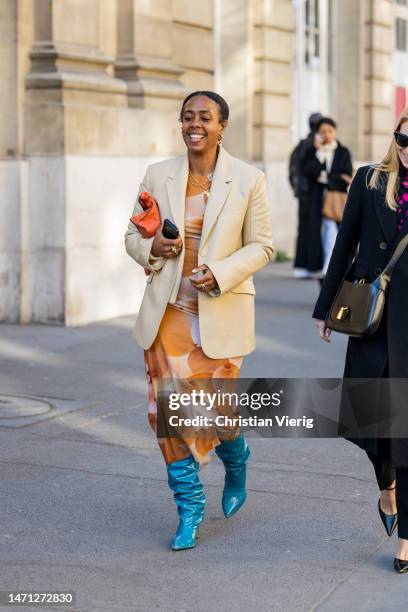 Guest wears beige blazer, dress outside Nina Ricci during the Paris Fashion Week - Womenswear Fall Winter 2023 2024 : Day Five on March 03, 2023 in...