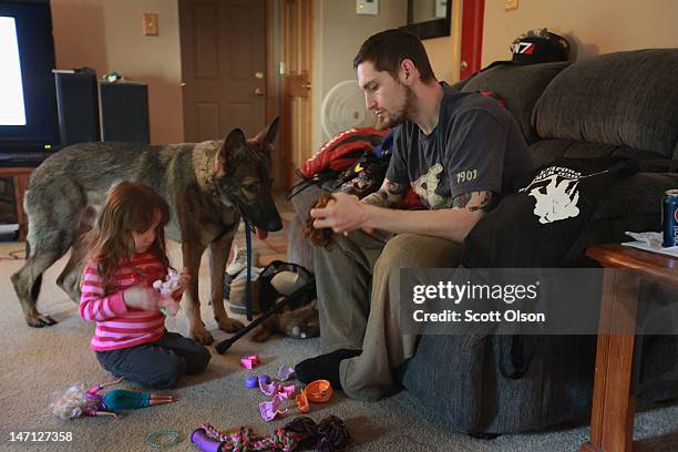 Army veteran Brad Schwarz plays with his three-year-old daughter Arabella and service dog Panzer at his home April 27, 2012 in Hanover Park,...