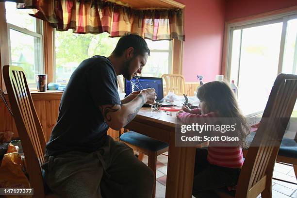 Army veteran Brad Schwarz hangs out with his three-year-old daughter Arabella at his home April 27, 2012 in Hanover Park, Illinois. Schwarz, who...