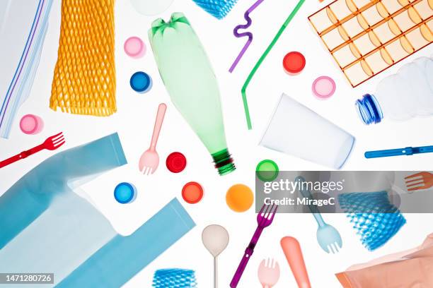 a variety of multi colored plastic garbage flat lay on white - plástico imagens e fotografias de stock