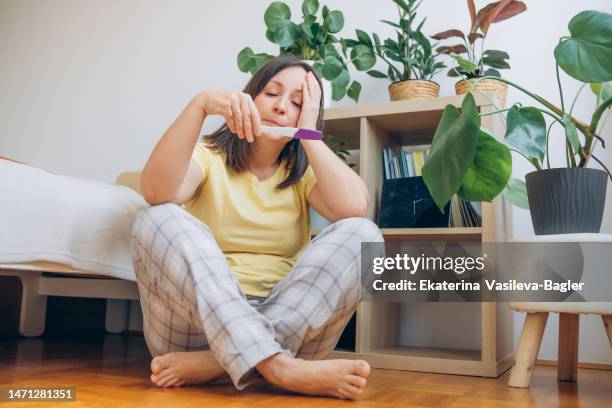 woman holding a pregnancy test - pregnancy test stock pictures, royalty-free photos & images