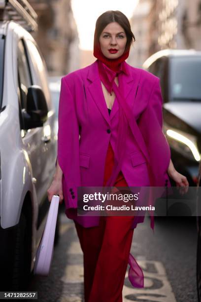 Guest wears a fuchsia blazer, red pants and red balaclava, outside Victoria Beckham, during Paris Fashion Week - Womenswear Fall Winter 2023 2024, on...