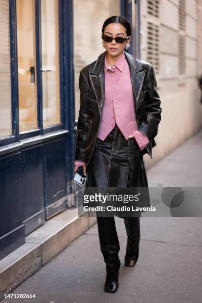 Yoyo Cao wears a pink shirt, pink vest, brown leather blazer with matching skirt and black boots, outside Victoria Beckham, during Paris Fashion Week...