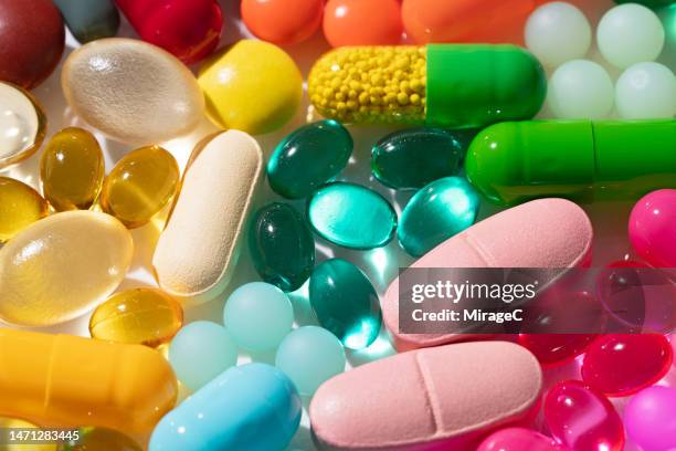 a variety of multi colored medicine pills and capsules - comprimés photos et images de collection