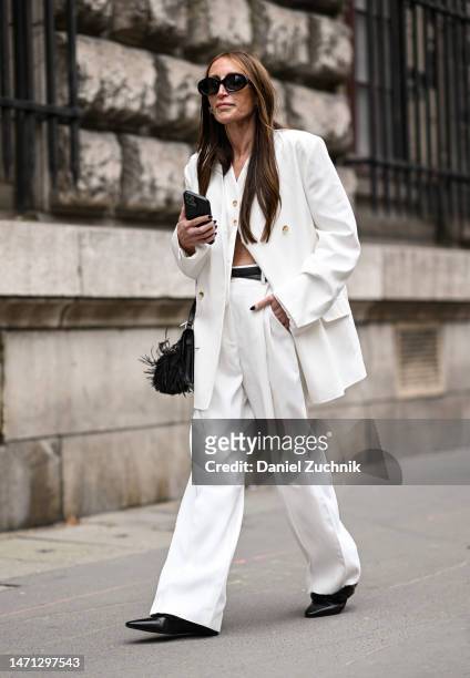 Chloe Harreuche is seen wearing a white jacket, white pants, black sunglasses and black bag outside the Hermes show during Paris Fashion Week F/W...